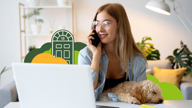 Smiling investor working from home with dog on lap, laptop open and phone in hand