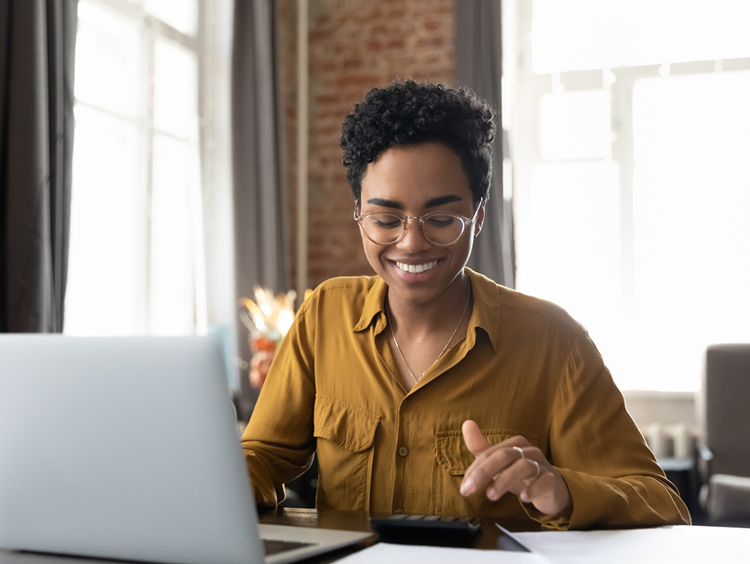 Investor working at desk with laptop and calculator, focused on deal analysis