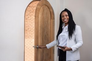 Real estate investor opening front door with clipboard in hand