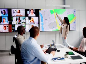 Investors at conference table viewing Zoom call and property map for Drive for Dollars strategy